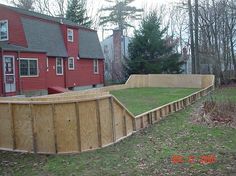 a large wooden fence in front of a red house