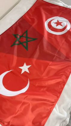 two flags are laying on the ground next to each other, one is red and white