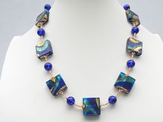 "Vintage Murano Glass, 1990-1996, two colored cobalt blue and aqua teal ,\"Exposed Gold\", Squares, Venetian Bead Necklace, with 24 Karat Gold Foil.  Each bead is handmade, one-by-one in Venice, Italy, and are lampworked beads. Necklace has 20mm Square beads and 10mm round beads.  Necklace is accented with gold bead caps, and small crystal and gold faceted crystals; length is approximately 18 1/2 Inches, adjustable to 20 1/2 inches, with adjustable gold filled  link chain and gold, lobster style, spring clasp." Blue Polished Beads Party Jewelry, Blue Polished Bead Jewelry For Parties, Blue Polished Beads Jewelry For Party, Elegant Blue Beaded Necklaces With Large Beads, Elegant Blue Beaded Necklace With Large Beads, Formal Blue Single Strand Beaded Necklace, Blue Czech Glass Necklace With Large Beads, Blue Czech Glass Jewelry With Large Beads, Blue Czech Glass Necklace With Polished Beads