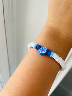 a woman's arm with a blue and white bracelet on it