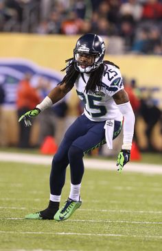 a football player running with the ball in his hand and people watching from the stands