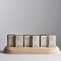 five books are lined up on a wooden stand