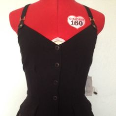 a woman's black and red dress with buttons on the front, attached to a mannequin