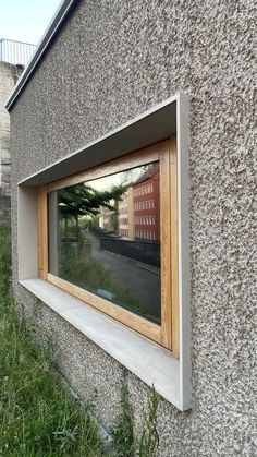 a building with a window and grass in the foreground