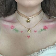 a woman with tattoos on her chest wearing a white top and pink flowers around her neck