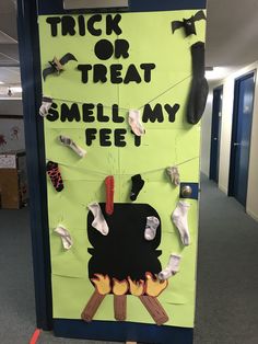 a bulletin board that says trick or treat smell my feet on the floor with socks hanging from it