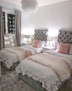 two beds with fluffy blankets and pillows in a white room next to eachother