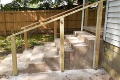 concrete steps leading up to a wooden fence