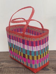 a multicolored basket sitting on top of a wooden table