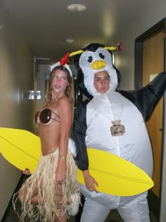 two people in costumes standing next to each other with surfboards on their feet and one person wearing a chicken costume