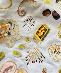 an embroidered table cloth with various items on it