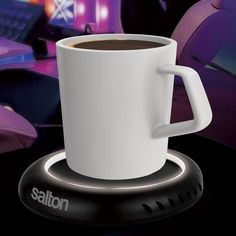 a white coffee cup sitting on top of a saucer next to a computer keyboard