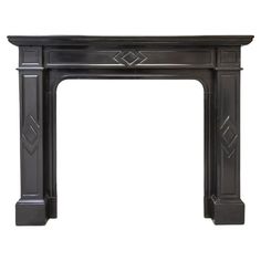 an antique fireplace mantel in black painted wood with geometric designs on the top and sides