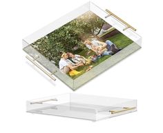 a clear acrylic box holds two photos and a gold bar on the bottom