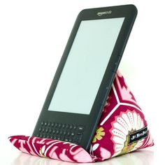 a cell phone sitting on top of a pillow in the shape of a flower pattern