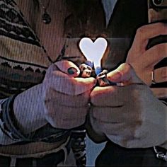 two people holding up their cell phones to show the light bulb in front of them