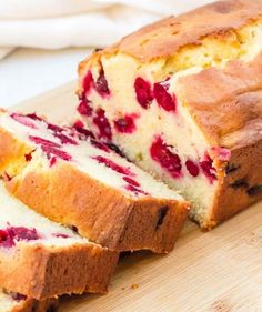 a loaf of cranberry bread on a cutting board with slices cut out and ready to be eaten