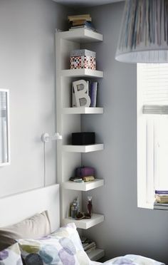 a bed room with a neatly made bed and a book shelf on the wall above it