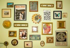 a wall with many different framed pictures on it