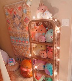 a shelf filled with lots of stuffed animals on top of a wooden floor next to a wall