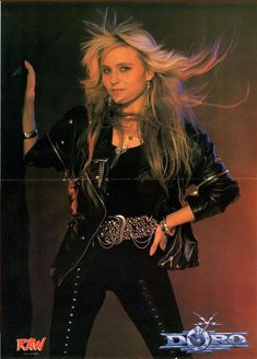 a woman with long blonde hair and black leather jacket posing in front of a red background