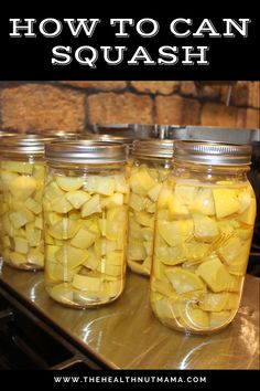 four jars filled with pickles sitting on top of a counter