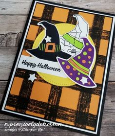 a happy halloween card with a witch hat and pumpkins on the front, sitting on top of a wooden table