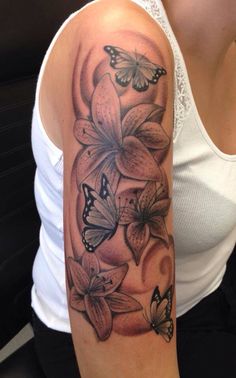 a woman's arm with flowers and butterflies on it