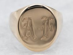 "This timeless signet ring is crafted from yellow gold and features a classic oval shape with an \"AF\" monogrammed top. Perfect for adding a hint of sophistication to any look, this ring is sure to be a treasured piece in any collection. Please note that this piece has its original monogram, and unfortunately, this piece cannot be altered without affecting the quality of the piece. Please feel free to contact us to help you find the perfect piece for your style and budget! Metal: 14K Yellow Gold Top Measurements: 14.3 x 19.2 mm, Oval Monogram: \"AF\" in Old English Ring Size: 10.25 Marks: \"14K\" Stamped on the inside band SKU #: A28742 Each piece has been identified and graded by a Graduate Gemologist who has been certified by the Gemological Institute of America (GIA). We have six brick Top Measurements, Signet Rings, Pocket Watch Chain, Gold Signet Ring, Gold Top, Gold Gift, Watch Chain, Yellow Gold Ring, Signet Ring