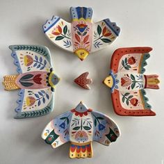 four colorful ceramic birds sitting on top of each other