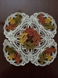 an embroidered doily with leaves on it