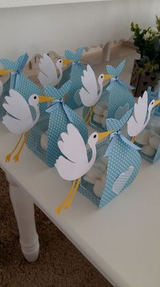 a table topped with blue and white cupcakes covered in stork paper