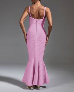 a woman in a pink dress with her back to the camera