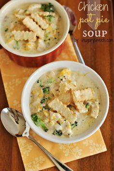 two bowls of chicken pot pie soup on top of a yellow napkin with spoons