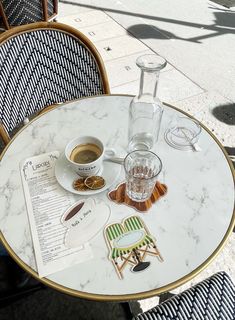 a table that has some food on it and a cup of coffee sitting next to it