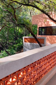 an orange brick wall next to a tree