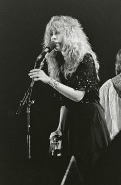 two women singing into microphones on stage