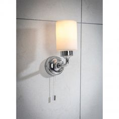 a bathroom light with a white shade on it's face and a wall lamp attached to the side