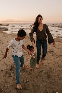 a woman and two children playing on the beach