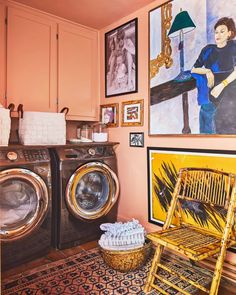 a washer and dryer in a room with pictures on the wall