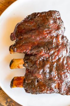 two pieces of meat sitting on top of a white plate