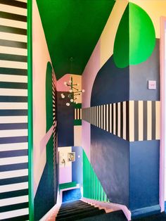 the hallway is painted in bold colors and has black, white, green, and blue stripes