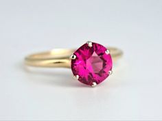 Beautiful antique ruby ring from the Victorian era in 14K yellow gold. This lovely ring features a 7.25mm, 1.5ct round-cut ruby with lovely fuchsia hues in a late Victorian Tiffany-style 6-prong mount. The ruby is in excellent condition, free of any chips or scuffs, and appears to be original to the ring. In excellent vintage condition. Ring size 7 3/4 and easily sized up or down several sizes. Ring sizing service available; please see sizing fees listed below. Please allow two weeks for sizing. One month layaway payment plans on items $500 and over available. Approximate Age - Victorian Gemstone(s) - tests as ruby/corundum on presidium gem tester (not simulated) Metal - 14K yellow gold Weight - 2.4 grams Ring size - 7 3/4 Marks - 14K mark Makers Mark -  Comments -  If you require ring siz Antique Ruby Ring Victorian, Classic Pink Ruby Ring With Brilliant Cut, Pink Ruby Ring With Round Band, Pink Ruby Round Ring, Classic Pink Ruby Ring With Prong Setting, Pink 14k Gold Solitaire Ruby Ring, Classic Pink Lab-created Ruby Ring, Classic Pink Solitaire Ruby Ring, Pink Ruby Ring With Brilliant Cut In 14k Gold