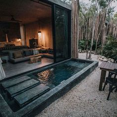 an outdoor living area with a pool and patio furniture in the background, surrounded by bamboo trees