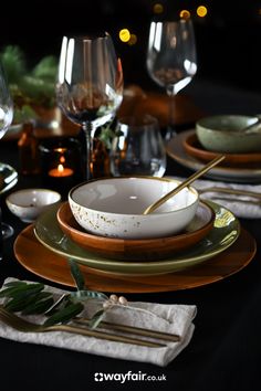 the table is set with plates, silverware and wine glasses for dinner guests to enjoy