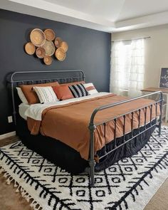 a bed sitting on top of a white rug in a bedroom next to a window