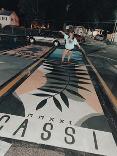 a woman standing on the side of a road pointing at something in the air with her hand