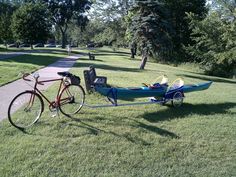 a bike parked next to a canoe on the grass