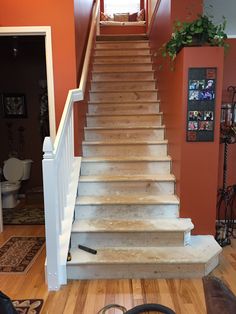 the stairs in this house have been stripped off and are being painted orange with white trim