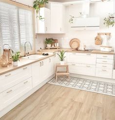 a kitchen with white cabinets and wooden floors